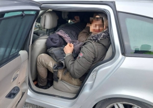 FOTO: Aizturētie migranti automašīnā