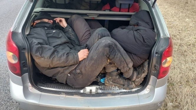 FOTO: Aizturētie migranti automašīnā