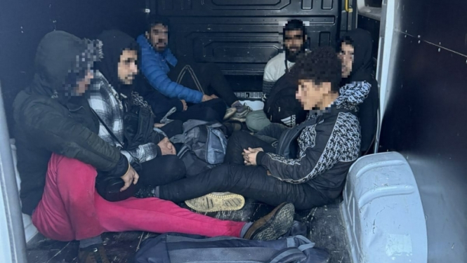 FOTO: Atturētie migranti automašīnā